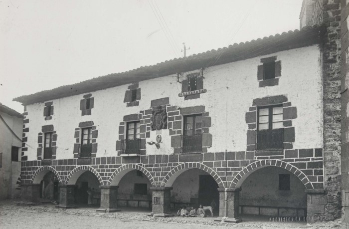 Vista general de la casa consistorial de Cirauqui, fachada. Bajo el pórtico inferior del edificio, un grupo de niños. 